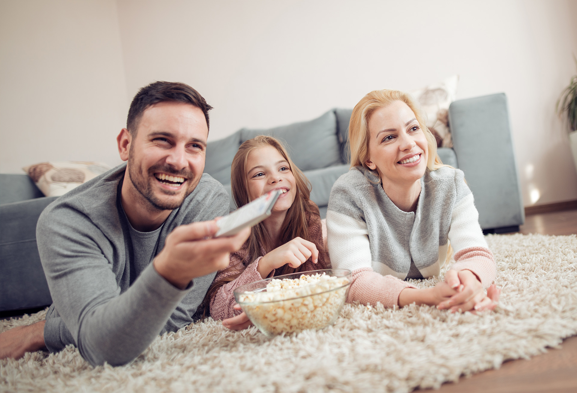 Familie entspannt zuhause mit Schutz durch passende Haushaltsversicherung